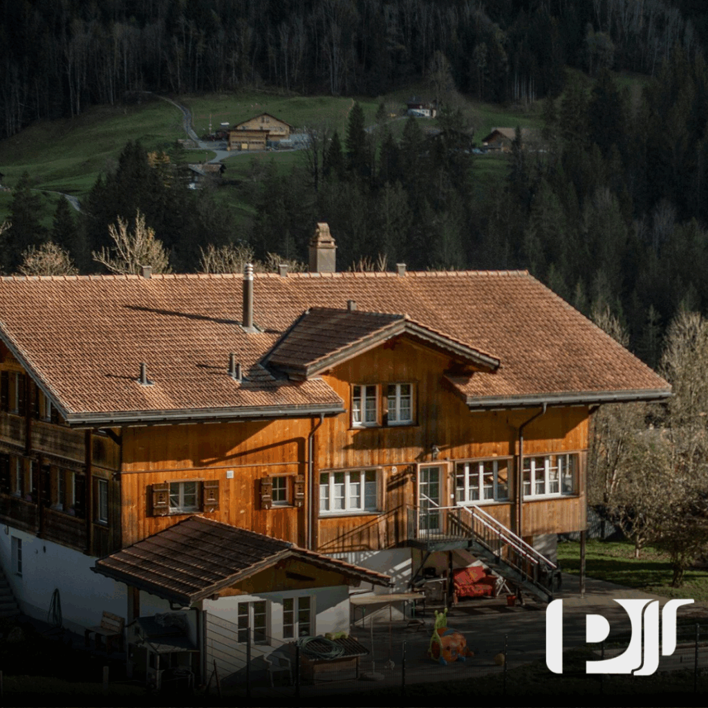 Imagem de uma casa entre as árvores de Campos do Jordão