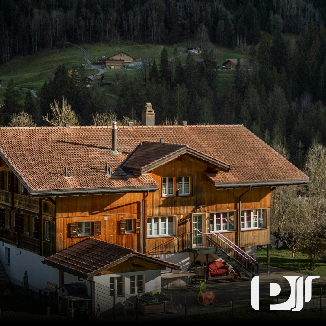 Imagem de uma casa entre as árvores de Campos do Jordão